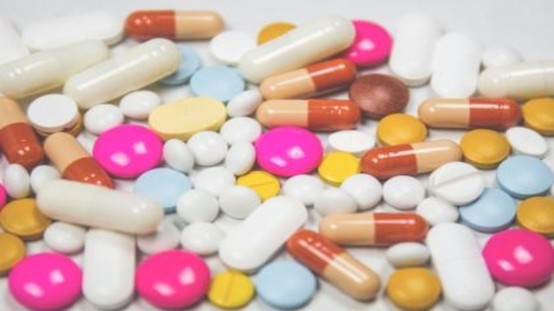 多種顏色與形狀的藥丸、藥片與膠囊堆疊在一起,示意藥物數量繁多。